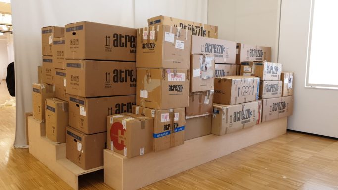 Varios paquetes de cartón apilados en una superficie de madera clara.